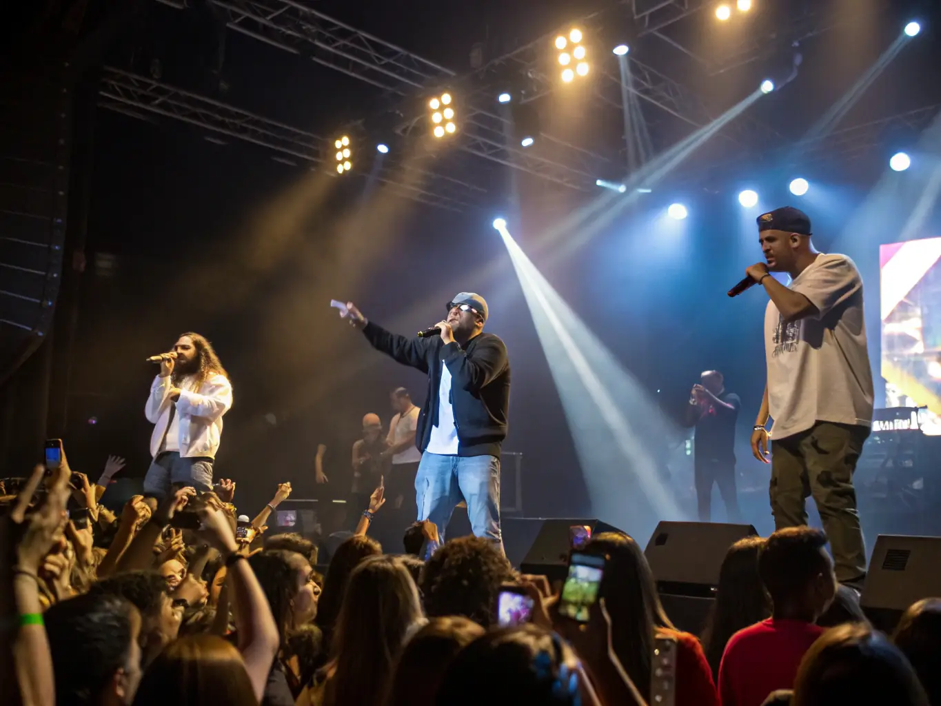 A photograph capturing the energy of a live amateur musical performance, with performers on stage and an enthusiastic audience, highlighting the cultural enrichment provided by Les Bichettes de la Rochelle.